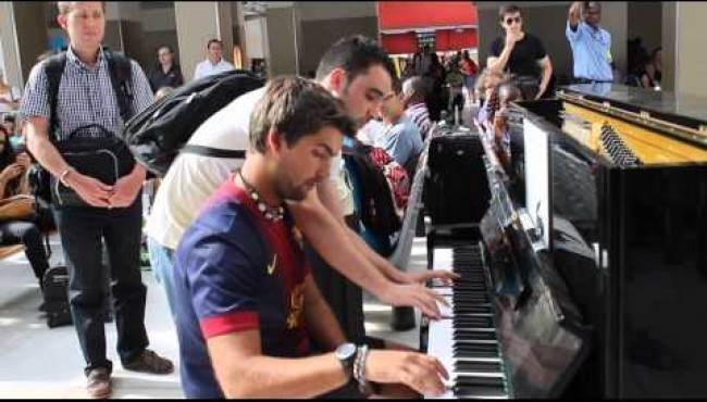 Dos extraños improvisando sobre un piano en la estación de trenes de Paris